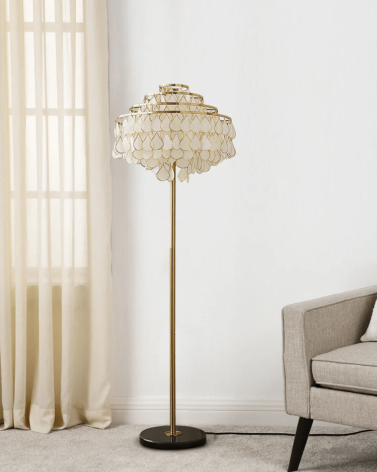 Sheer curtains and a cream armchair sit beside this Clérachic floor lamp in a sunlit corner.