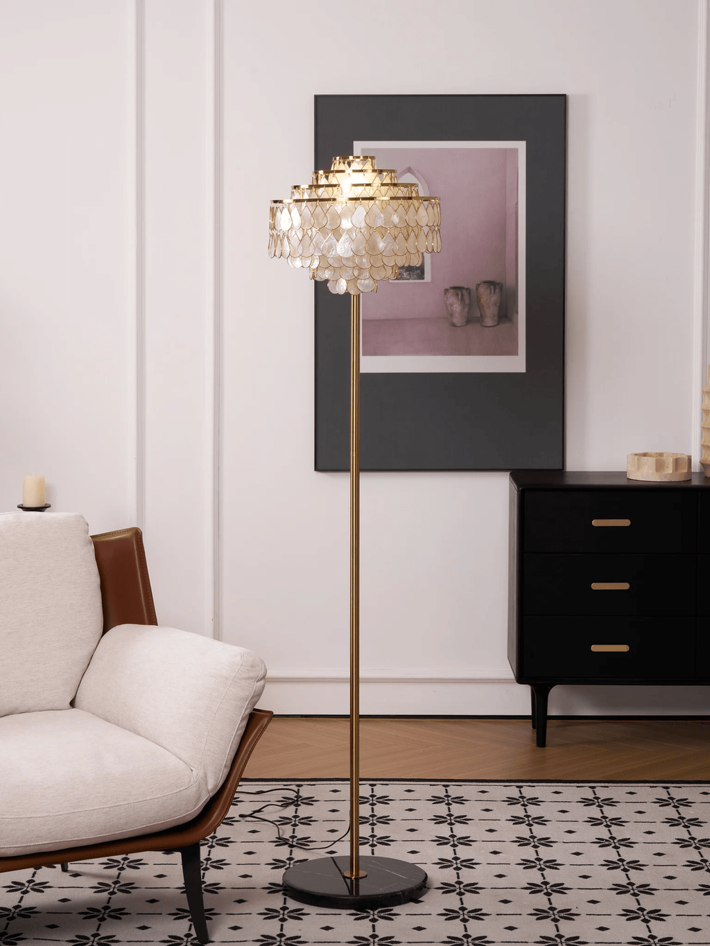 A black-and-white tiled floor sits beneath this Clérachic floor lamp, next to a dark dresser with brass pulls.
