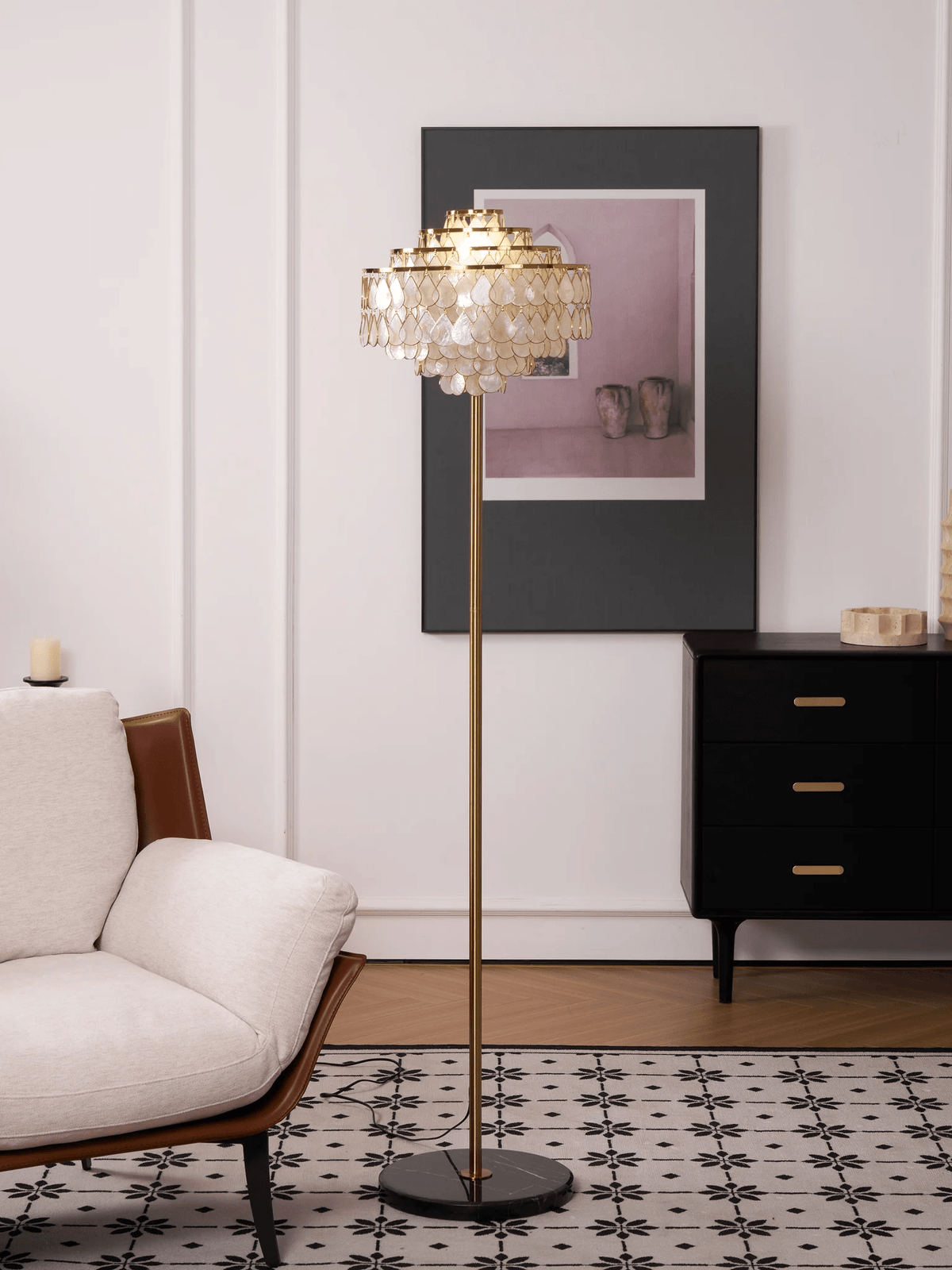 A black-and-white tiled floor sits beneath this Clérachic floor lamp, next to a dark dresser with brass pulls.