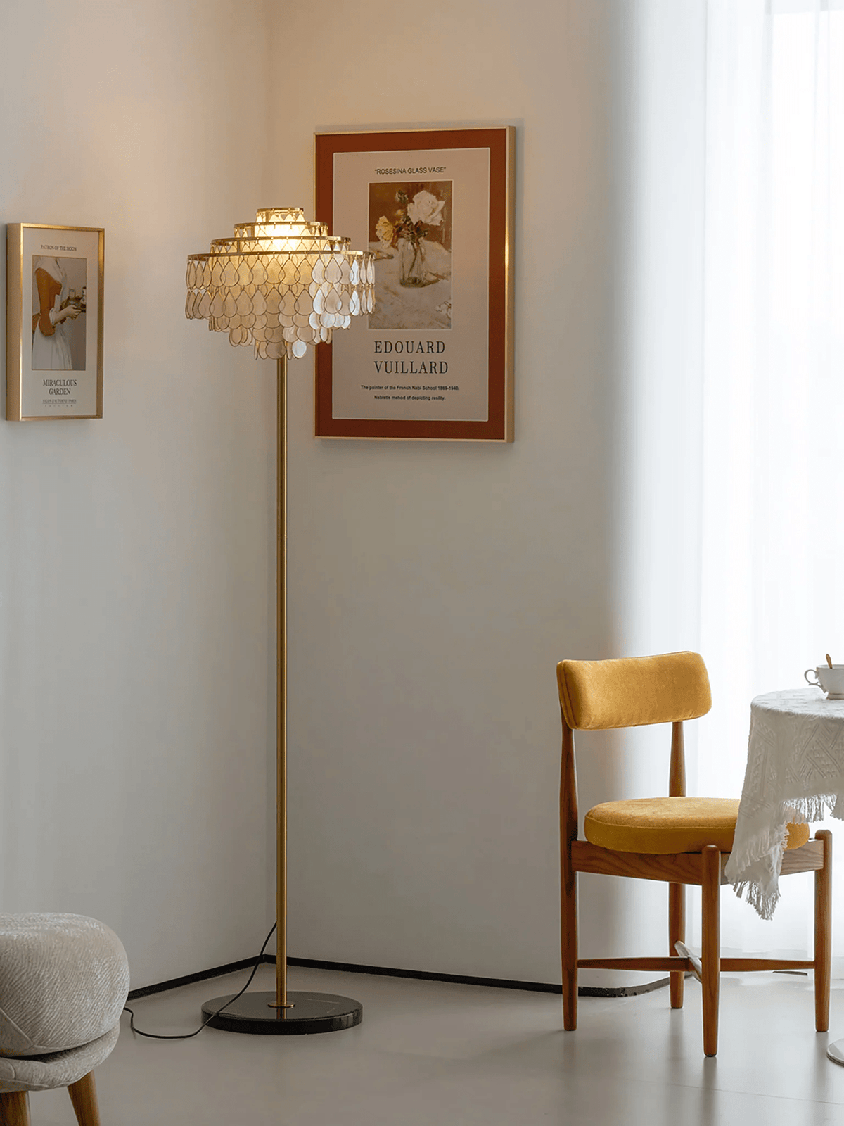 Warm plaster tones surround this Clérachic floor lamp, set beside a mustard chair and a draped round table.