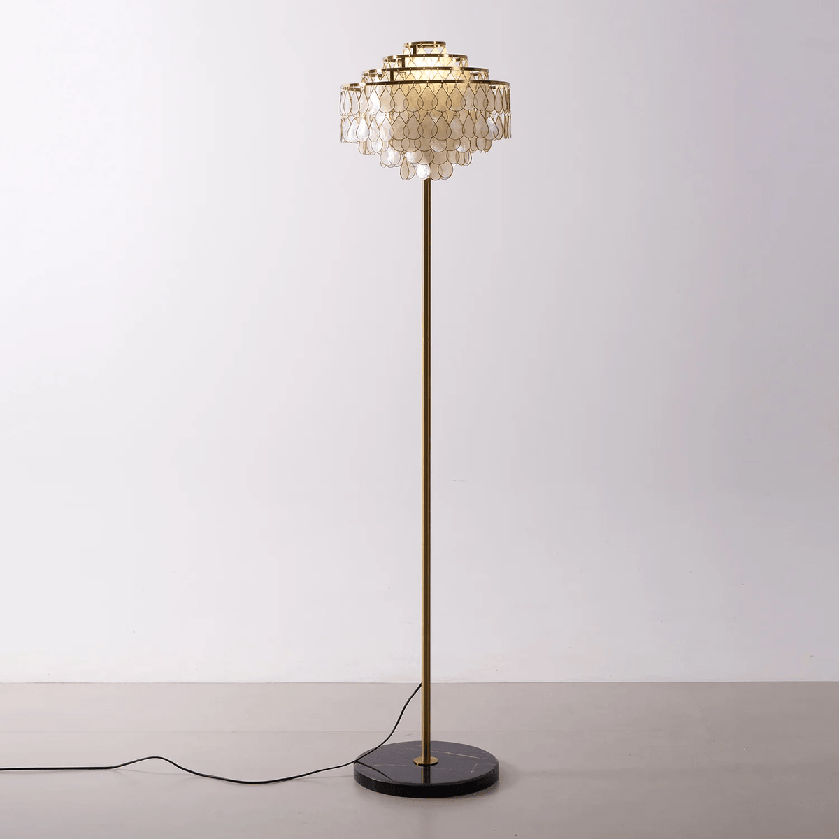 Cutout view of this Clérachic floor lamp on its round black marble base, against a plain backdrop.