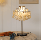 Close-up of the Clérachic table lamp's teardrop shade glowing above a plate of croissants and blueberries.