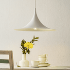 Yellow arch pendant light against a plain wall