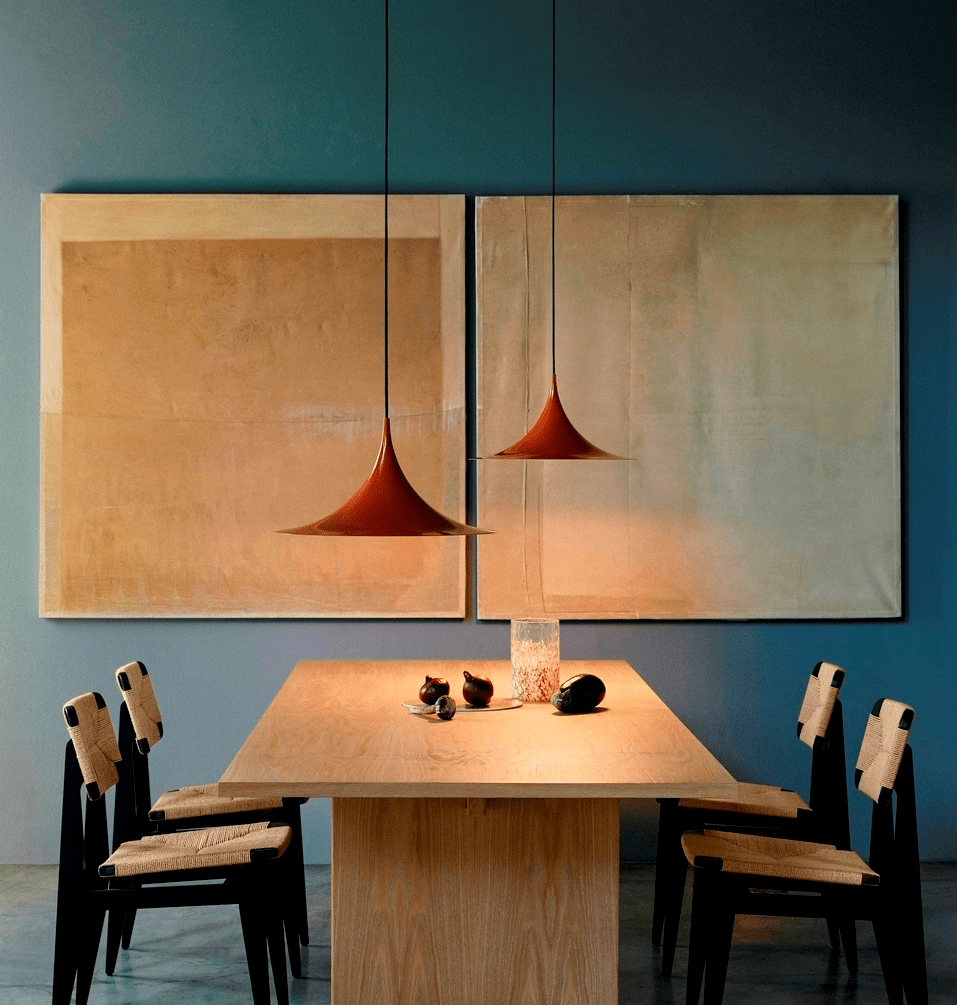 Arch pendant light shown lit in a dim evening room