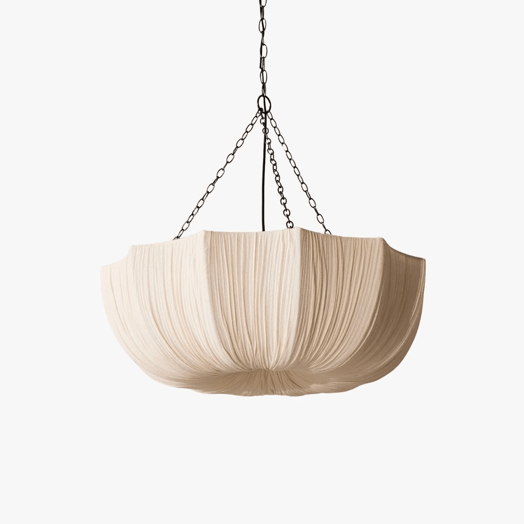 Gathered cotton pendant light glowing softly over a table