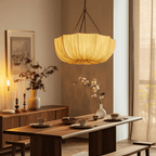 Gathered cotton pendant light hung low above a dining table