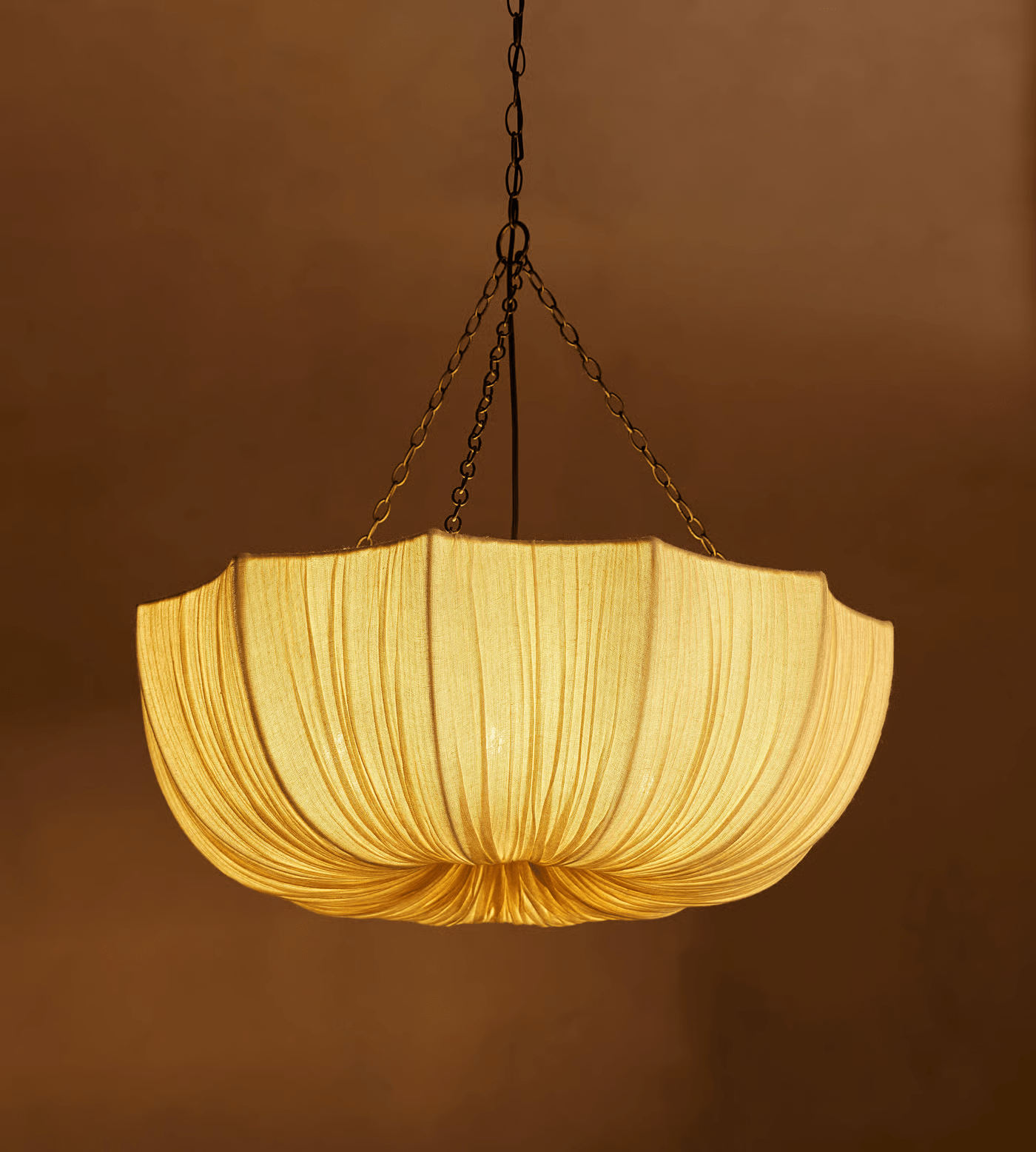 Gathered cotton pendant light casting a warm diffused glow