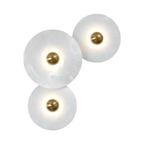 Three lit alabaster discs floating on white, polished brass centres and soft warm halos.