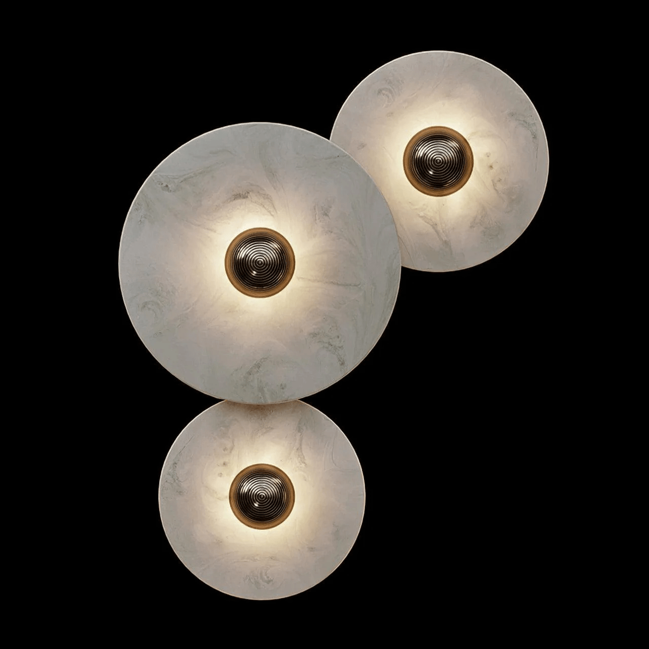 Lit three-disc arrangement on black: one large disc, one small above right, one below left.