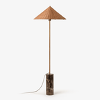 Clérachic rattan cone-shade floor lamp on a slim brass stem and dark marble cylinder base, shown full length on a plain white background.