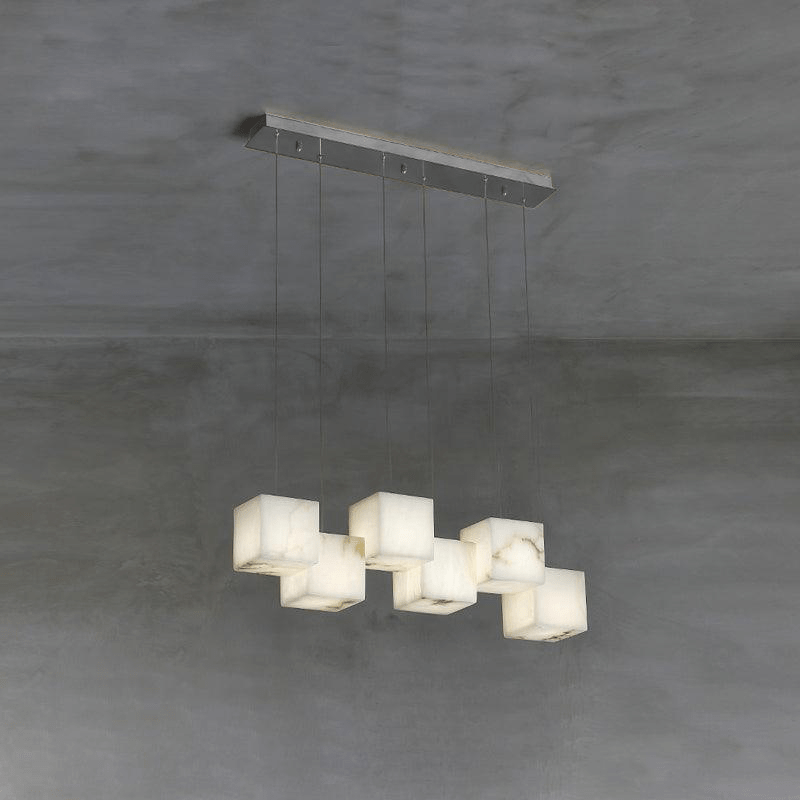 The Ivnoros linear chandelier in silver, six alabaster cubes staggered below a slim ceiling bar.