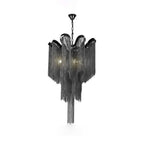 A black Clérachic chandelier, lit, is shown against a white backdrop with its chain fringe hanging in tiers.