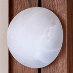 Close-up of the alabaster globe, its cloudy stone veining visible against slatted walnut.