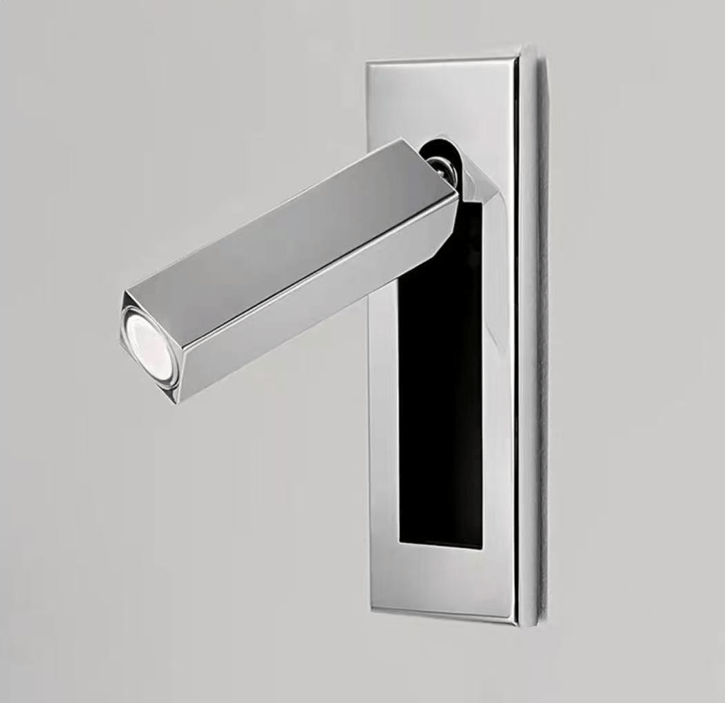 Slim recessed wall reading light glowing warmly beside a headboard