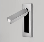 Slim recessed wall reading light glowing warmly beside a headboard