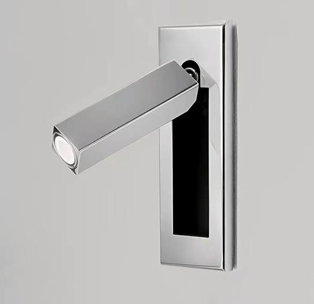 Slim recessed wall reading light glowing warmly beside a headboard