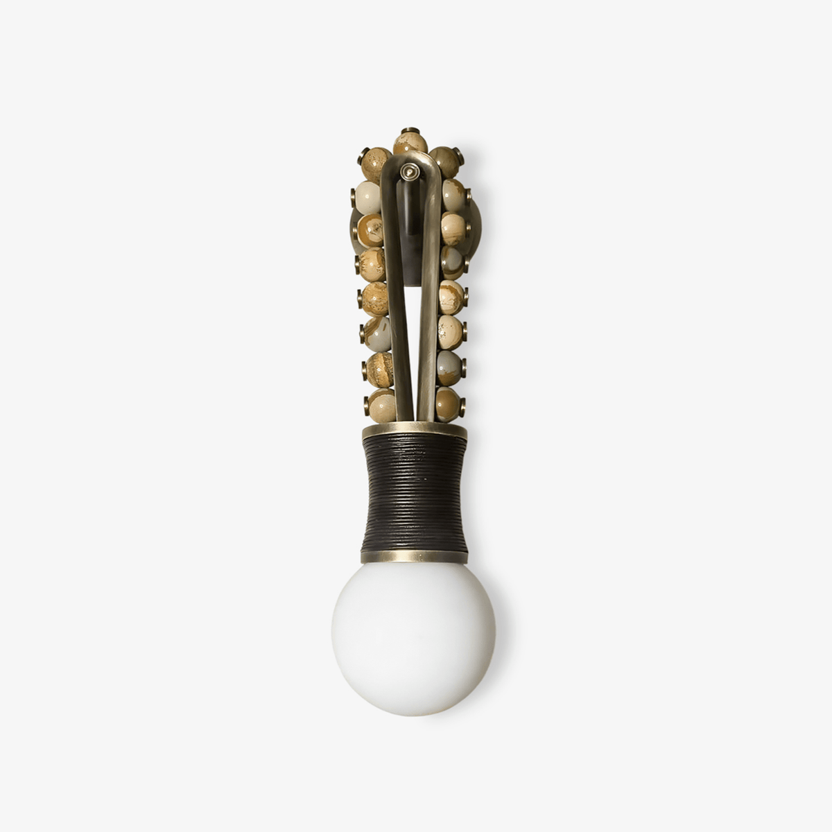 Clérachic wall sconce with cream stone beads down a brass frame and a black corded base, styled alone against a plain grey backdrop.