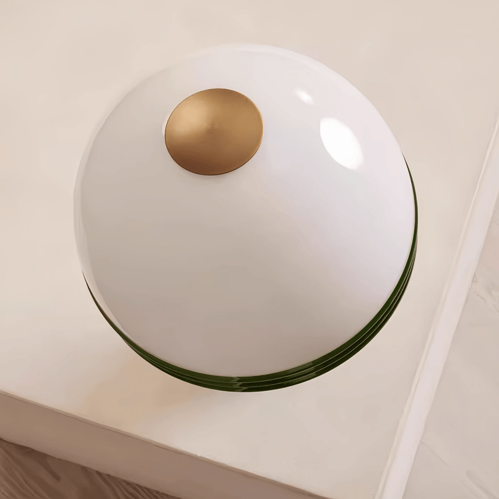 Overhead close-up of the Clérachic table lamp's glass dome, showing the small brass finial at its centre.