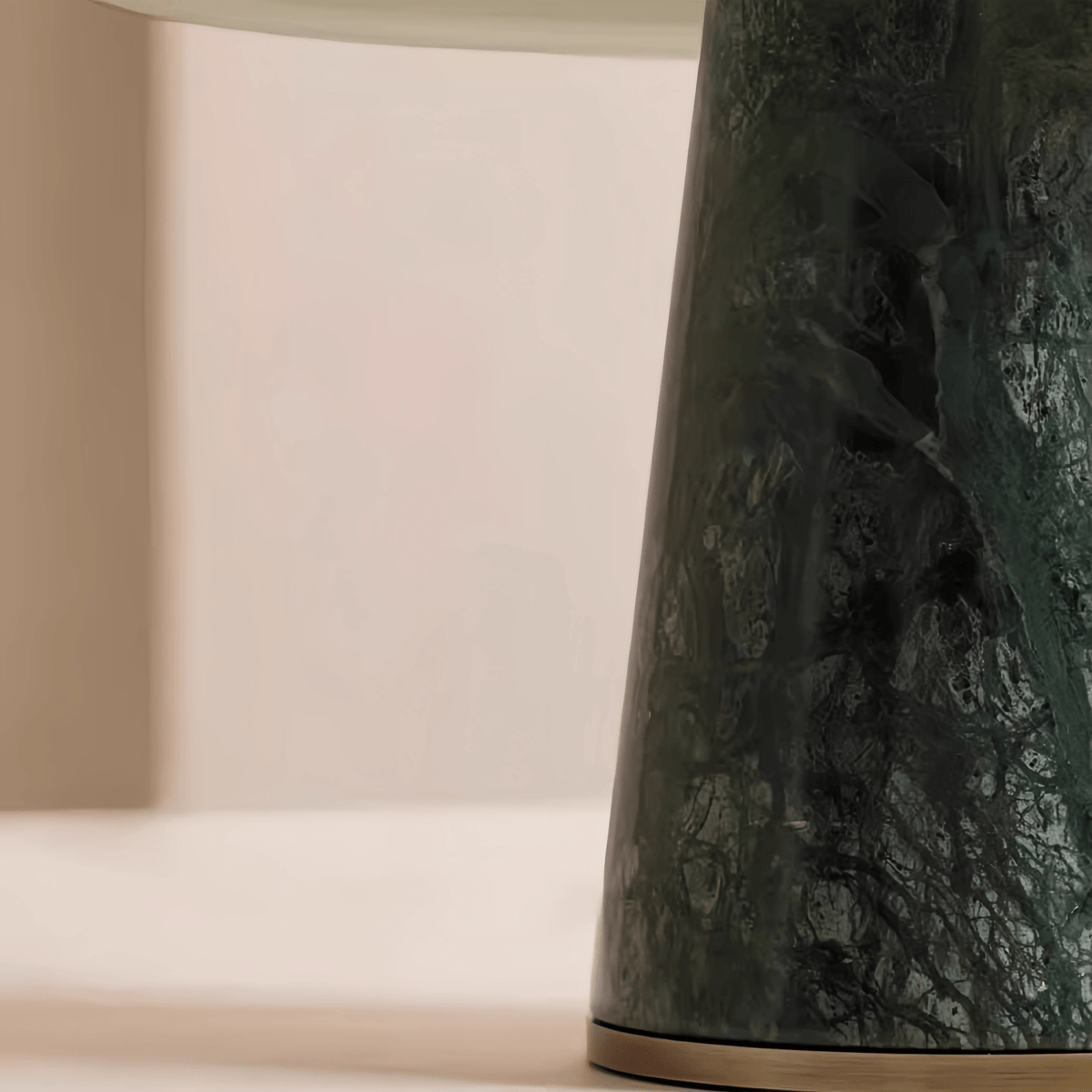 Macro close-up of the Clérachic table lamp's green marble base, showing its natural veining and tapered shape.