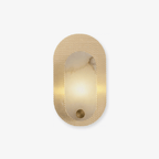 Perforated brass oval wall light on white, a lit alabaster panel set into the punched metal plate.