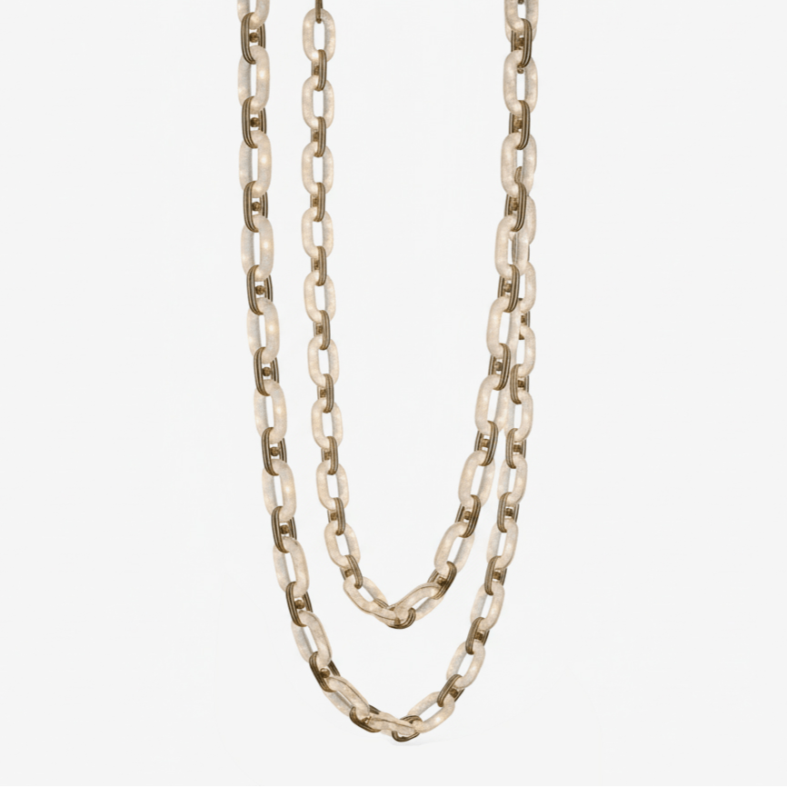 Alabaster chain-link chandelier unlit, its stone links looped in two swags on a plain backdrop