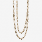 Alabaster chain-link chandelier unlit, its stone links looped in two swags on a plain backdrop