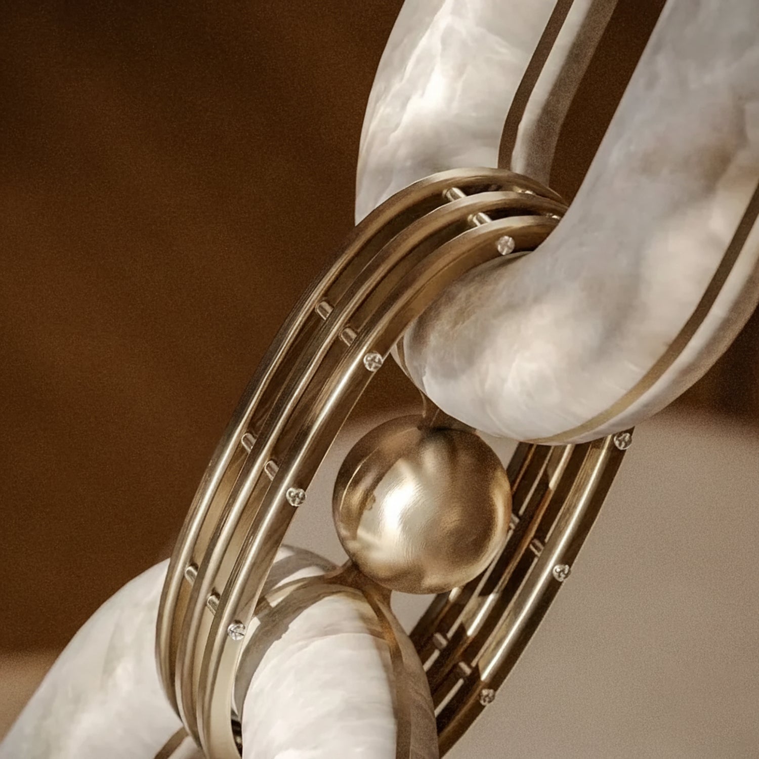Macro of one joint: a brass sphere and studded brass collar clasping two alabaster links
