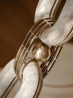 Detail of the brass ball and ringed collar joining two polished alabaster links