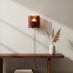 Wine-red glass wall sconce glowing in a dim room