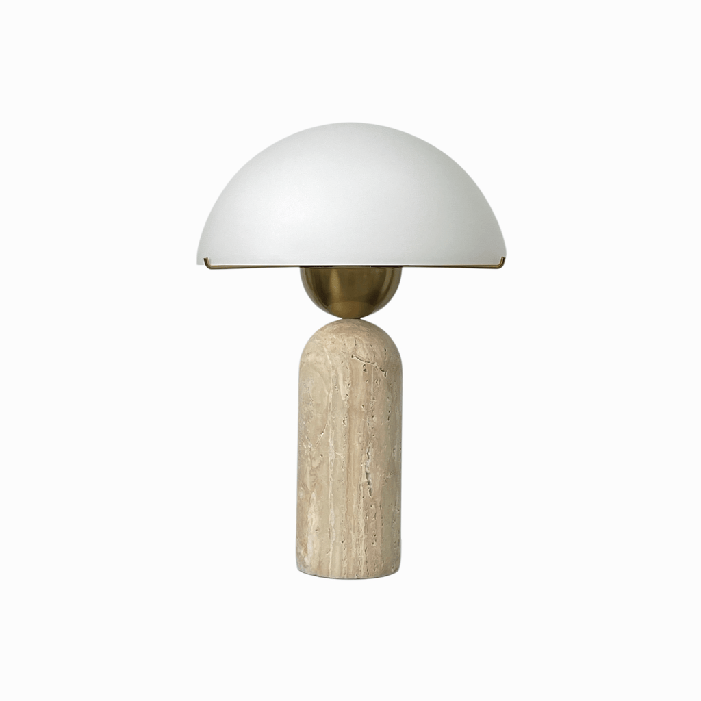 Studio shot of a Clérachic dome table lamp with a travertine base, its white dome shade shown unlit on white.