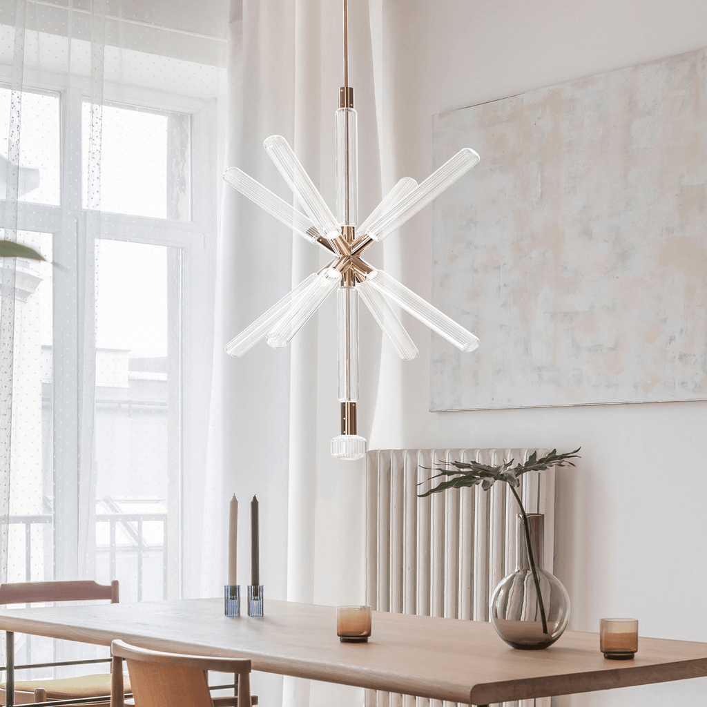 This Clérachic pendant lights a walnut dining table, its crystal rods bursting from a champagne-gold centre.
