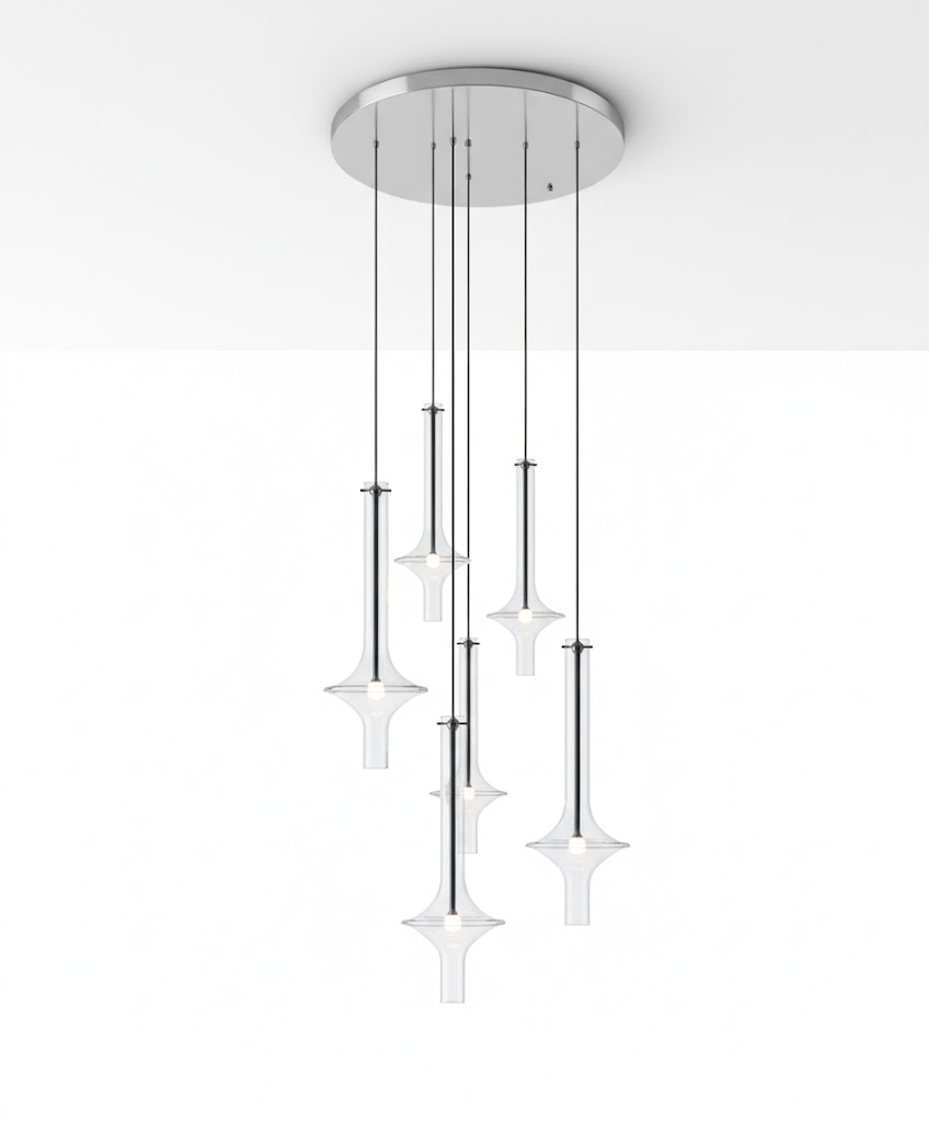 A cluster of lit Clérachic pendants in clear glass hangs from a round canopy fixed flush to a plain white ceiling corner.