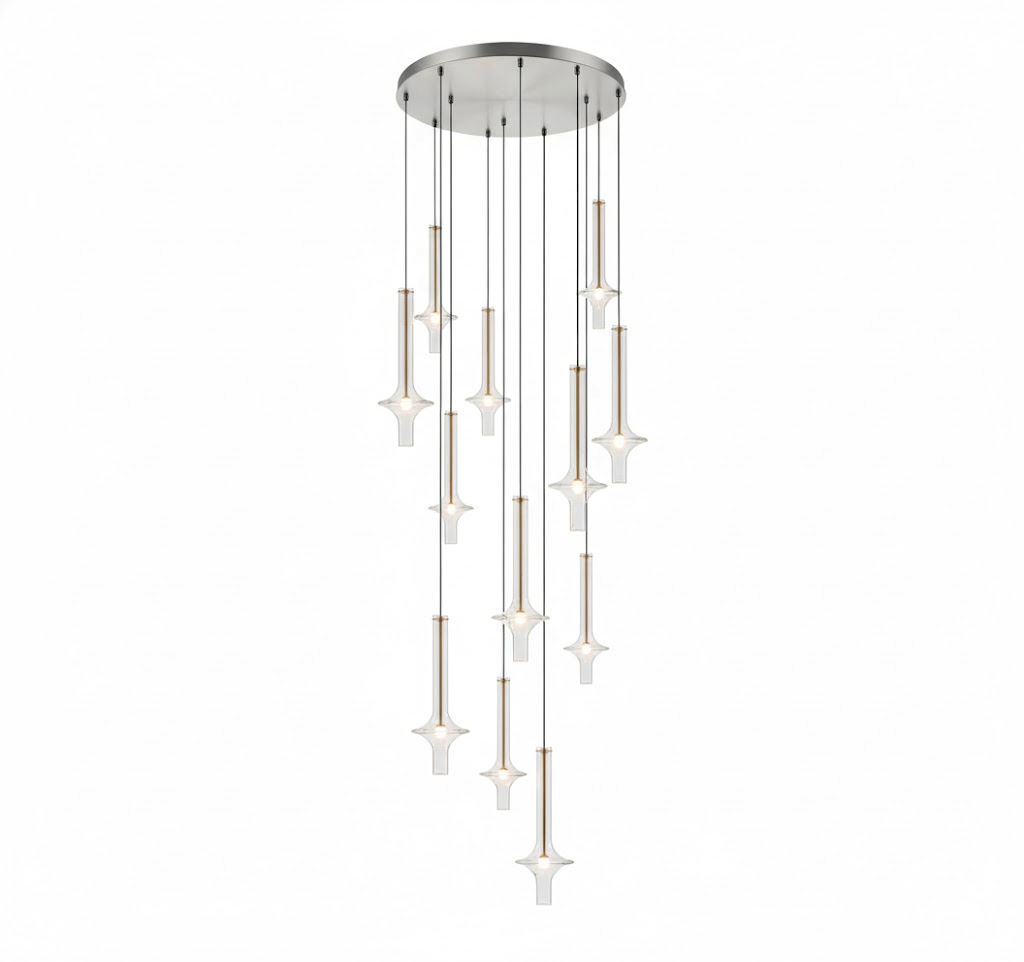 A cascade of Clérachic pendants in mixed clear and tinted glass drops from a round canopy, glowing warm against a white backdrop.