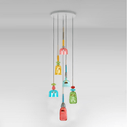 A spiral cluster of Clérachic pendants in coral, amber, teal and green glass hangs from a white ceiling plate, a coral shade lowest.