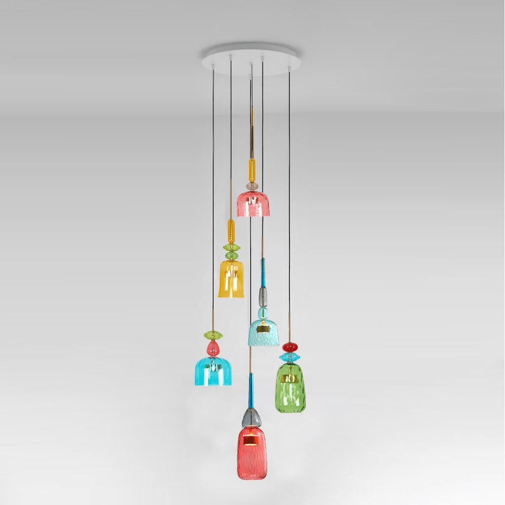 A spiral cluster of Clérachic pendants in coral, amber, teal and green glass hangs from a white ceiling plate, a coral shade lowest.