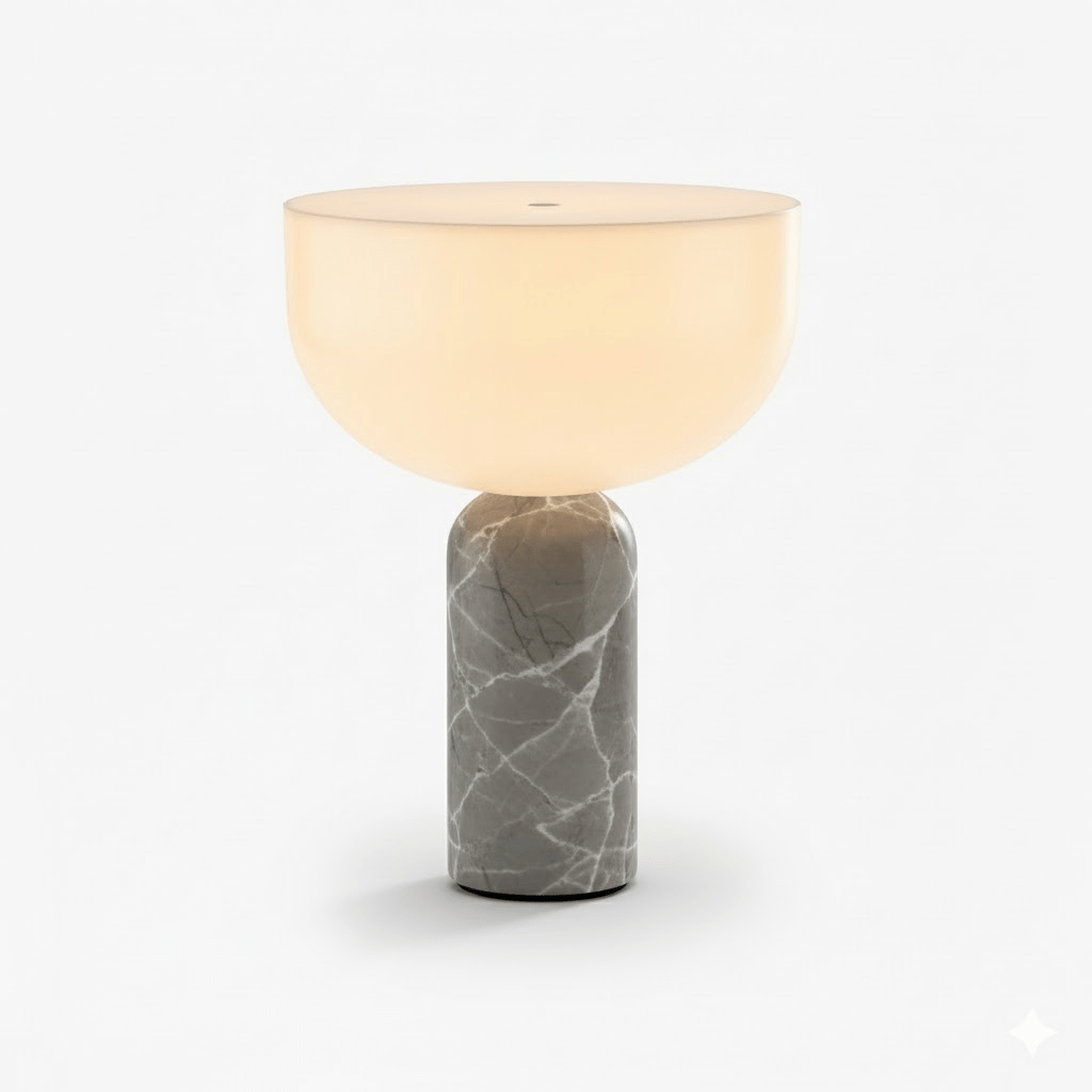 This Clérachic sphere table lamp in grey marble, lit and photographed against a plain light grey background.