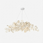 Dense leaf chandelier glowing above a dining table