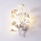 Detail of white ceramic ginkgo leaves on a gold frame