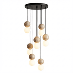 Nine cords cascade travertine and glass spheres at staggered heights from this Clérachic pendant's round canopy.