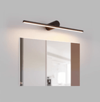 A lit Clérachic wall light spans a bathroom mirror framed in two-tone wood panelling.