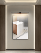 This Clérachic wall light glows above a framed abstract print in a warm, cove-lit alcove.