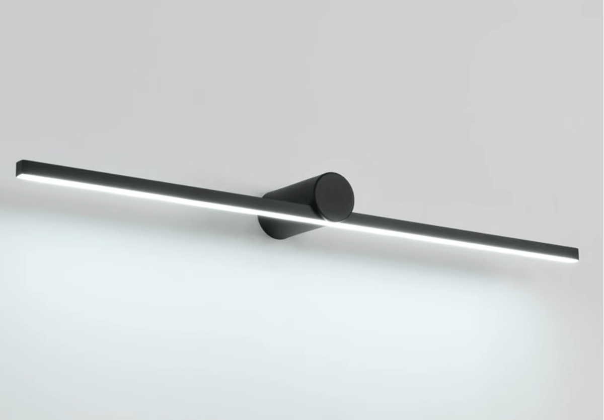 Studio shot of a Clérachic wall light glowing cool white, angled to show its slim profile.
