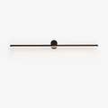 Studio view of a slim black Clérachic wall light, its round pivot mount and bar unlit against white.