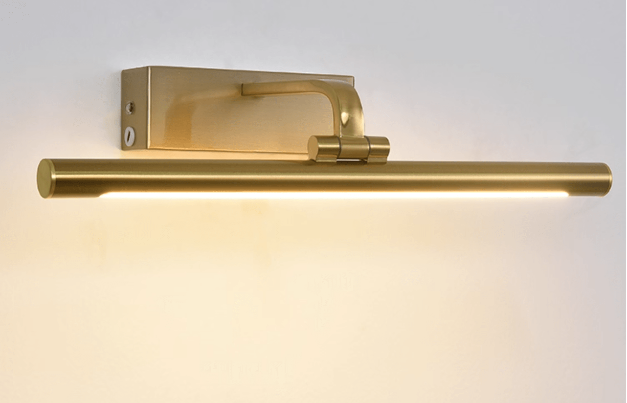 Picture light in gold finish lighting a portrait on the wall