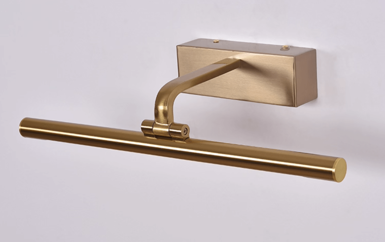 Gold frame light with remote control resting nearby on a surface