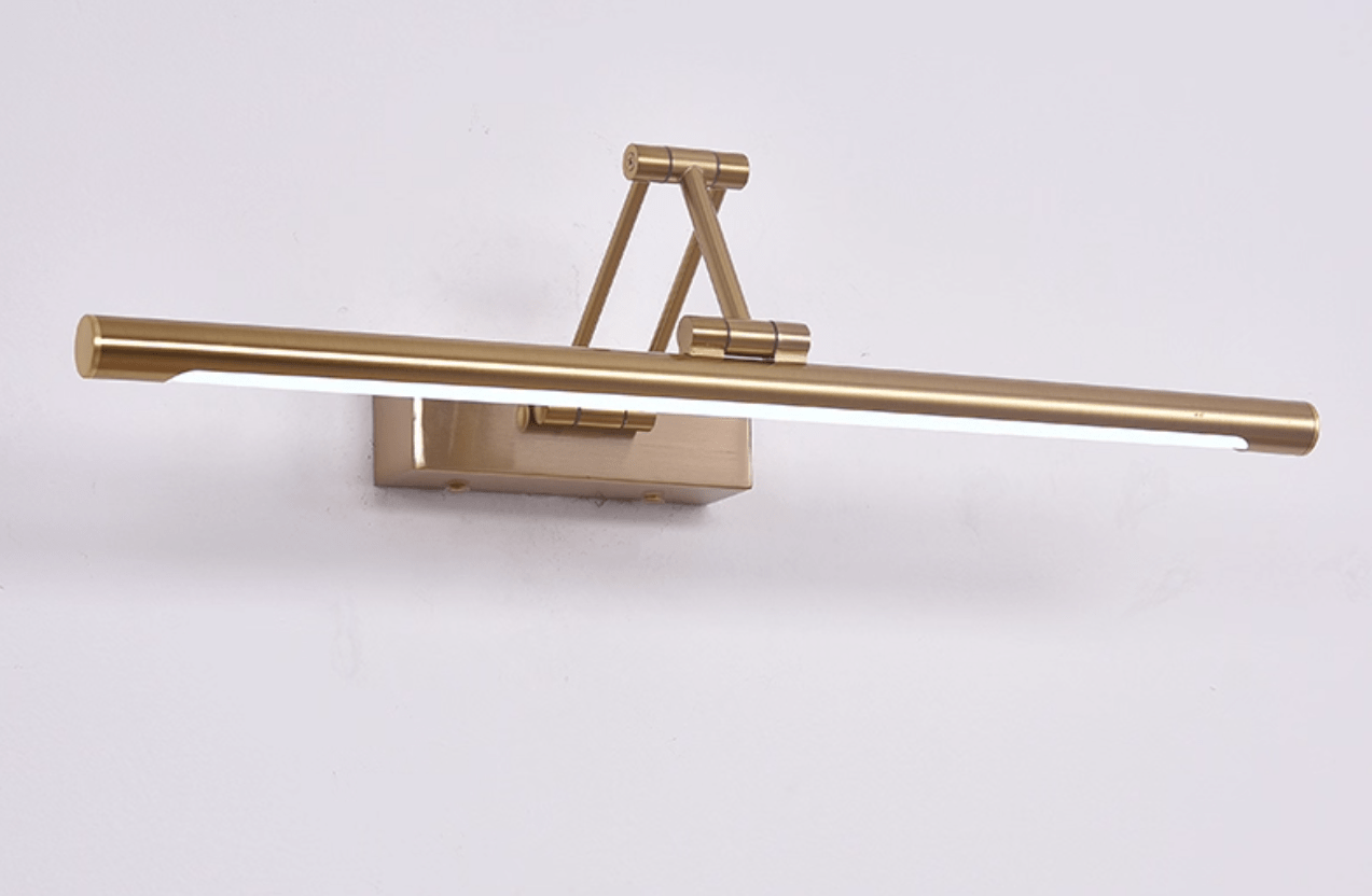 Gold wall light illuminating a mirror with soft even light
