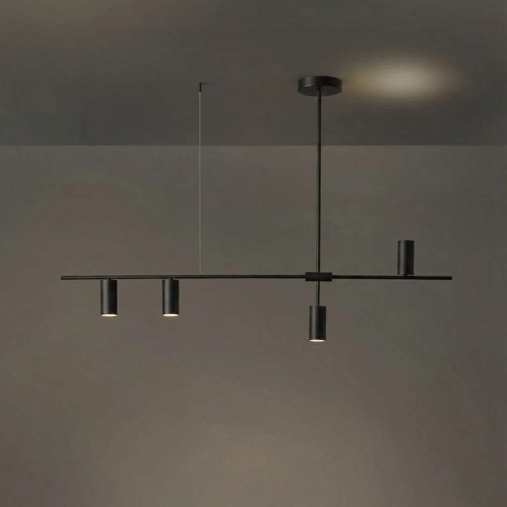 In a dark, low-sheen finish, this Clérachic chandelier hangs against a dim grey backdrop with a warm glow behind.