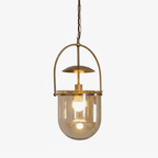 Gold frame pendant light with amber glass shade lit at night
