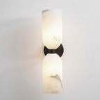 Two natural alabaster columns joined by a metal band on a wall