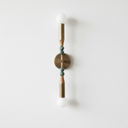 Antique brass wall lamp with marble accent on a neutral wall